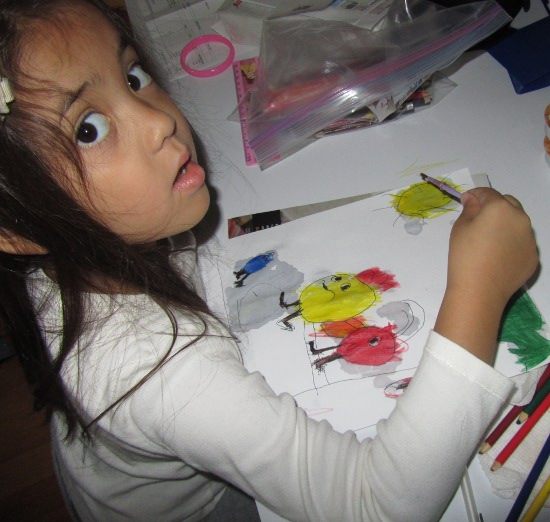 Yaya working on her water drawing of Peep, Chirp and Quack