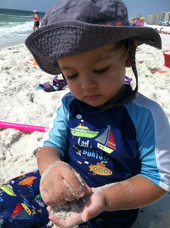 Adik intensely enjoys playing with sand