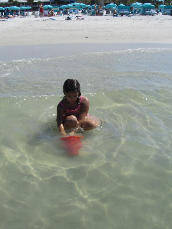 Yaya plays with a bucket in the sea