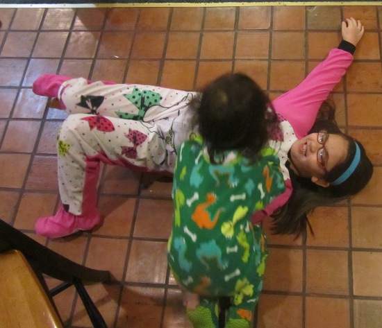 Some game involving Yaya on the floor and Adik climbing on her