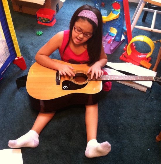 Yaya sings and plays the guitar