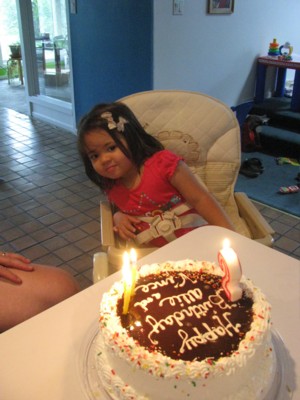 Admiring her cake with lit candles