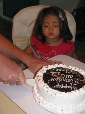 Yaya watches intently as Papa cuts the cake