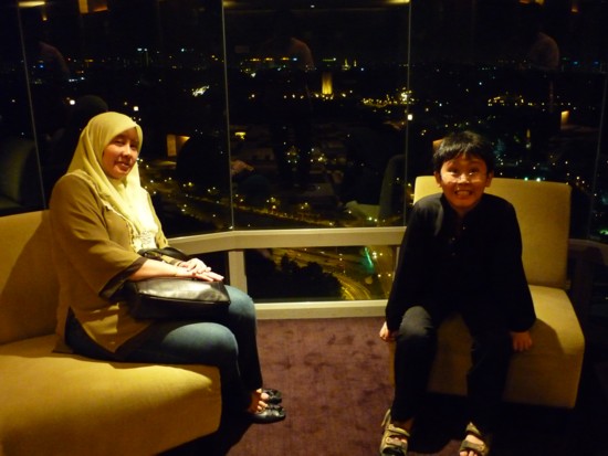 Yong and Irfan on the 31st floor elevator banks, KL skyline lit up in the background