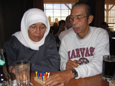 Mak and Abah playing the peg game